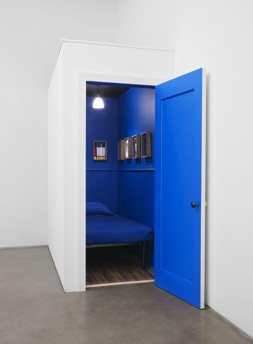 Elaine Reichek a réalisé une chambre cabine acoustique. L'intérieur est bleu avec un lit et une petite étagère.