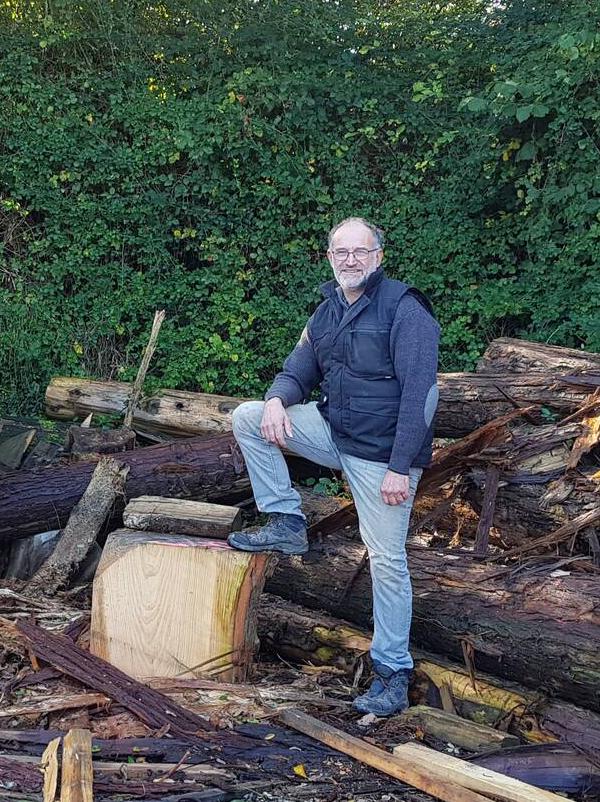 Jean-Marie Grau est debout, un pied sur une souche souriant et fière de sa scierie qu'il a nommé scierie des cèdres et de ses choix. Son bois provient du grand ouest de la France. Du cyprès de Lawson, de Lambert et du chêne. Il est basé à Locmaria Grand-Champ et réalise parquet et matière première pour du mobilier.