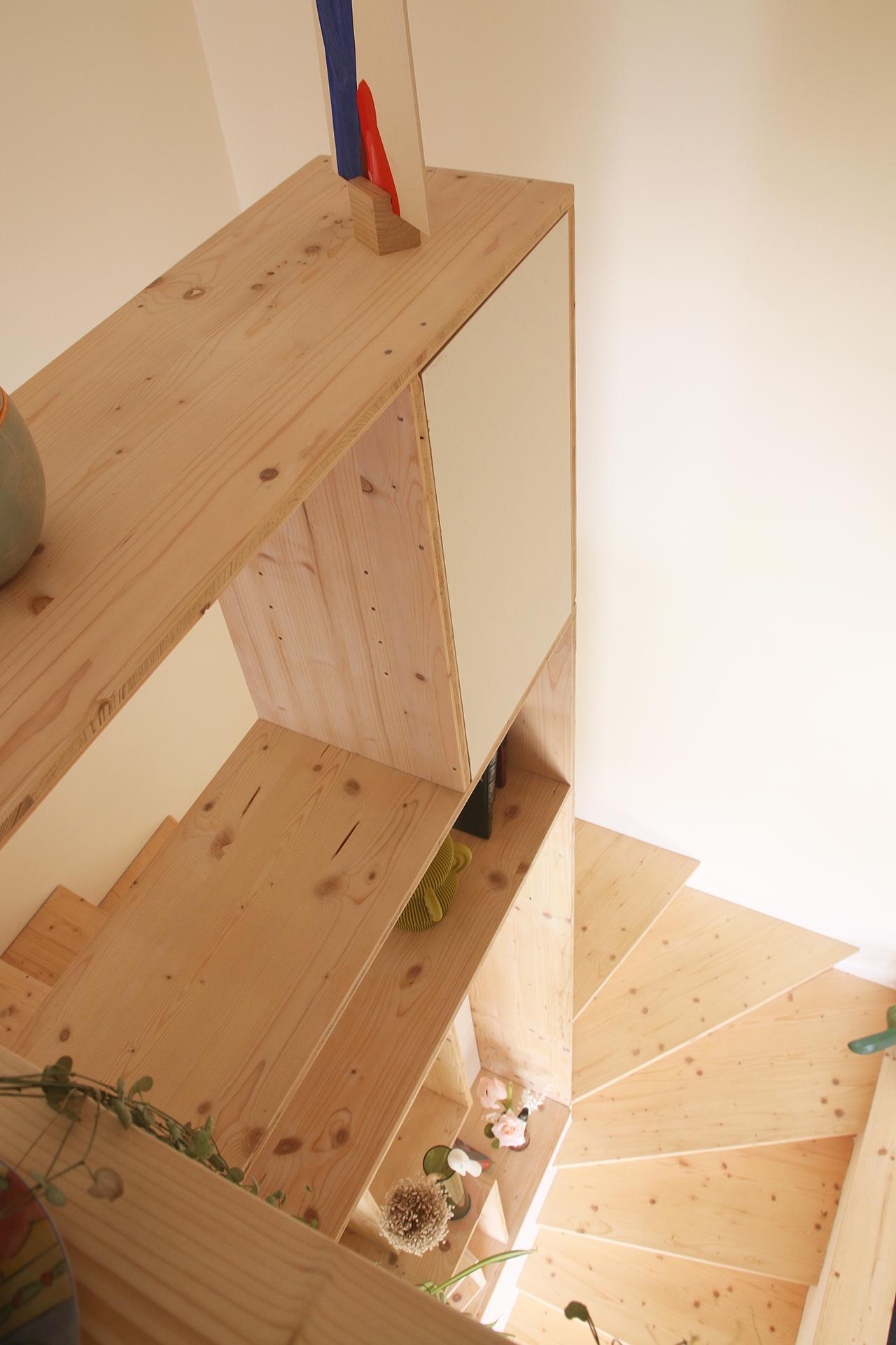 Vue en contre-plongée de l'escalier bibliothèque réalisée en bois par Jérôme Barrier, designer sur mesure à Vertou