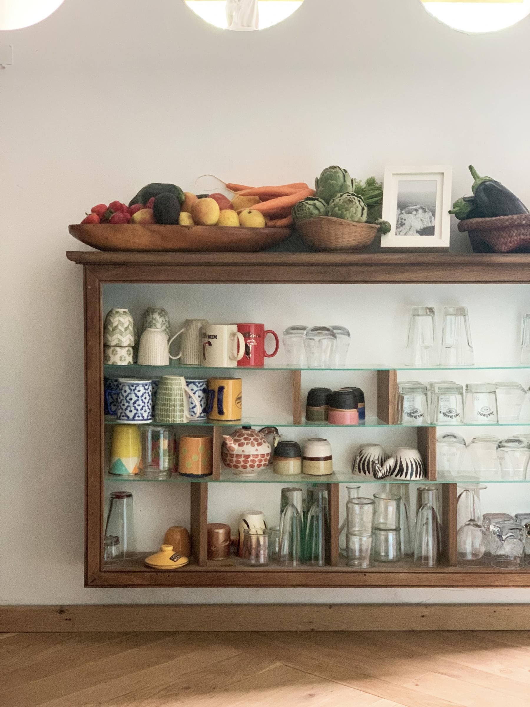 Ici, nous avons conservé la structure en bois massif d'un ancien vaisselier et ajouté des étagères en verre pour mettre les verres et les tasses. 