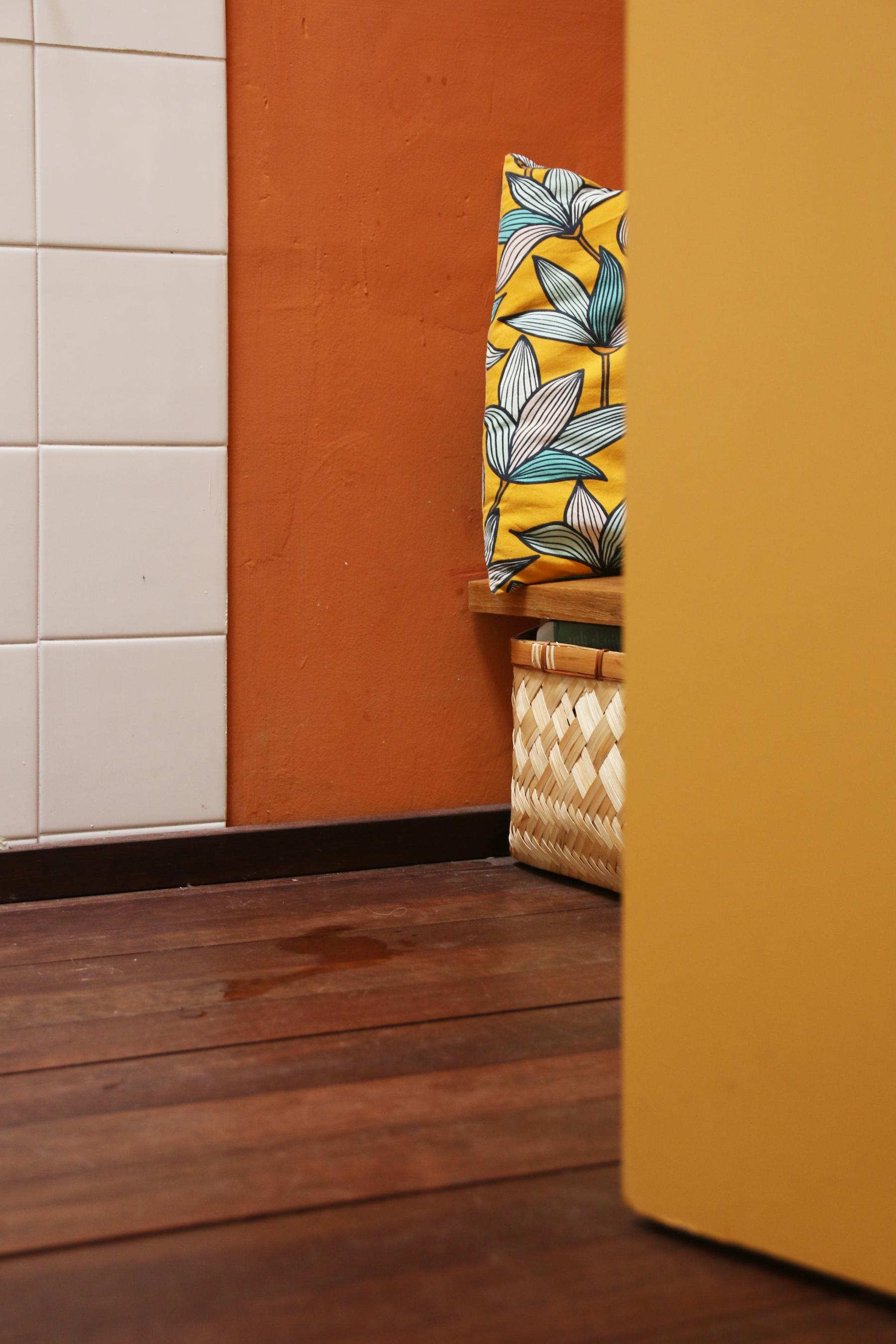 Détail sur le sol en bois massif recyclé et le banc en chêne avec des rangements en bambou tresséde la salle de bain sur mesure à Vertou imaginée par Jérôme Barrier.